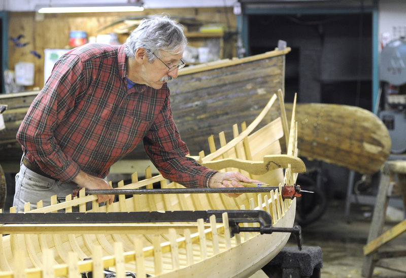 Stelmok works on one of the classic wooden canoes turned out in his factory in Atkinson.
