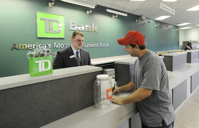 DJ Peterson, a customer service representative, helps Matthew Hodgins open a new account at TD Bank on Allen Avenue in Portland. The bank is open 7 days a week with expanded hours as it focuses on service.