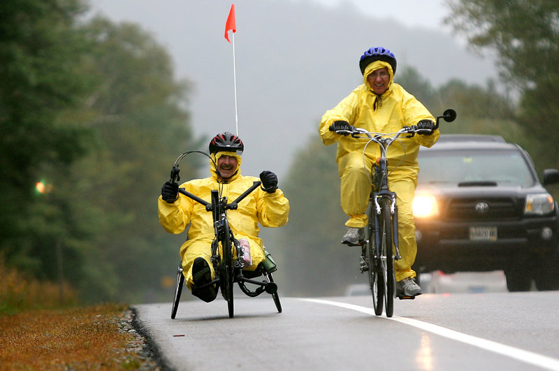 Amputee Joe Severs, left, of Highland, Ill., with wife Mary, bike in the rain on the first day of a three-day bike race Friday in Franconia Notch, N.H. The ride, now in its seventh year, is a fundraiser for Northeast Passage, a UNH program that offers sports and recreation activities for people with disabilities.