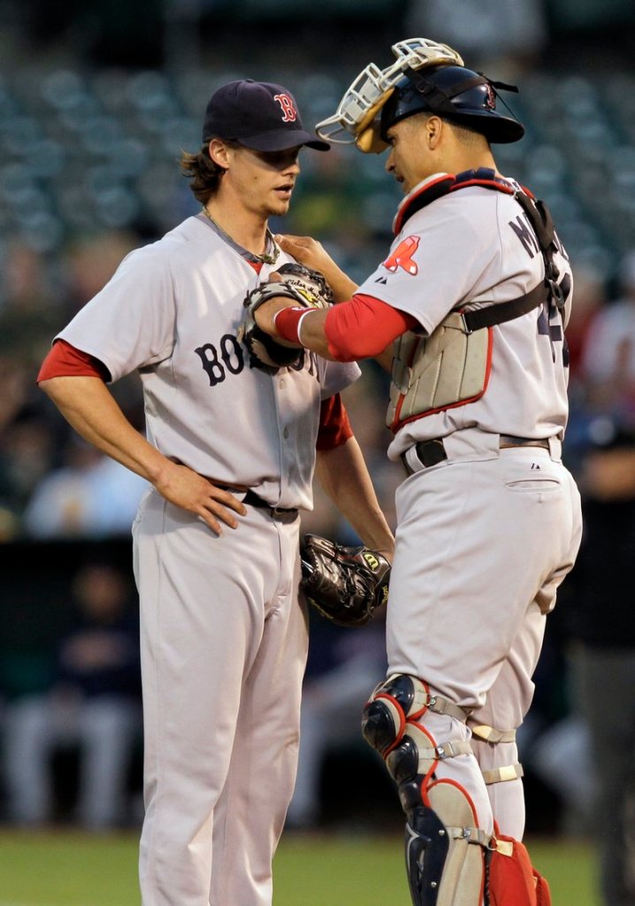 Red Sox pitcher Clay Buchholz and catcher Victor Martinez chat at the mound after Oakland’s Kurt Suzuki’s two-run double in the first Friday night.