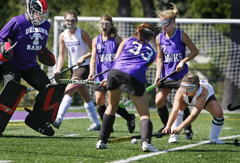 Jesse Cinque, right, of Deering tries to prevent Marshwood’s Shea Costin from taking a shot against goalie Caley Presby during their SMAA field hockey game Saturday in Portland. Marshwood won, 2-1.