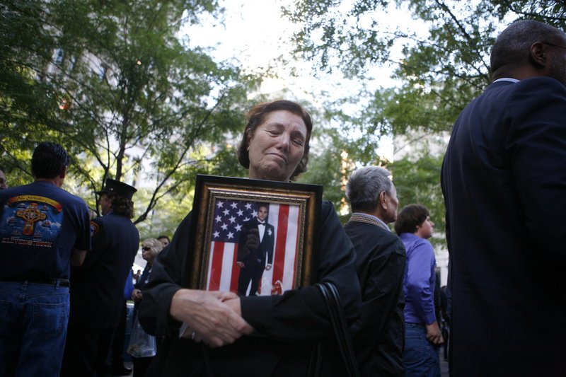 Anna Sereno of Brooklyn, N.Y., holds a photo of her son, Arturo Angelo Sereno, as friends and relatives of the victims of the Sept. 11, 2001, attacks gather on Saturday for a remembrance ceremony at Zuccotti Park, adjacent to ground zero in New York.