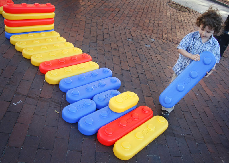 Oisin Malakie McCullough, 3, of Portland gets creative with giant blocks outside The Children's Museum & Theatre of Maine during the Space Gallery Block Party on Congress Street in Portland on Saturday.