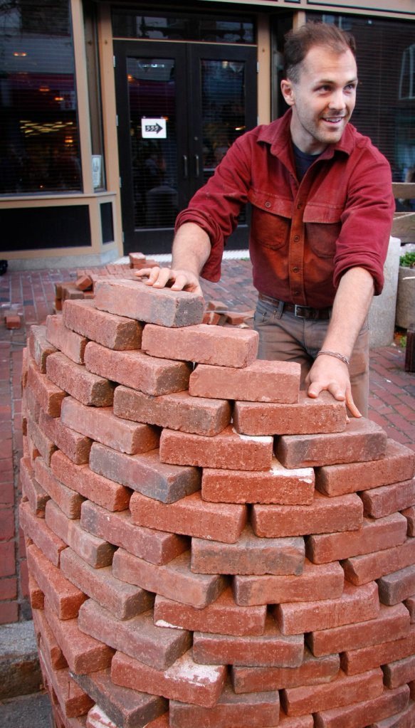 Artist Colin Sullivan-Stevens pauses while creating his temporary installation piece titled "Bricked Out" during the Space Gallery Block Party.