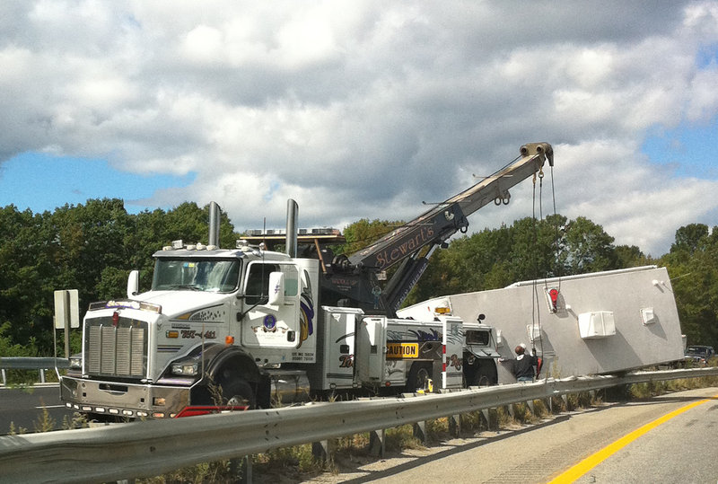 A large camper was damaged as it rolled over and onto a median guardrail Wednesday when the driver of the pickup truck that was hauling it swerved to avoid a post on Interstate 295.