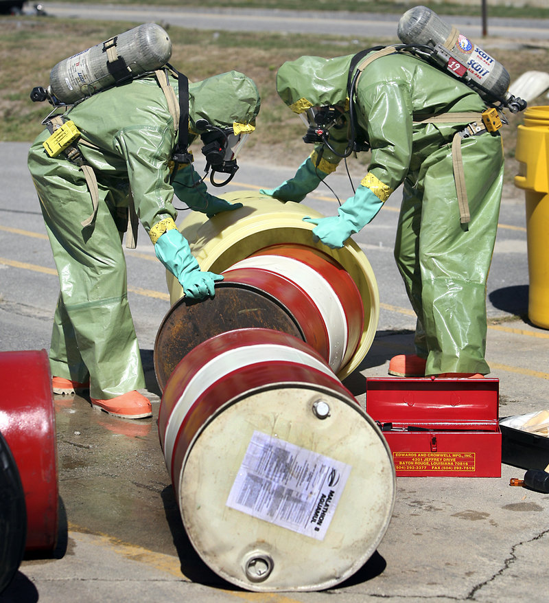 Members of Portland’s Fire Department move a drum of potentially hazardous material into a containment barrel during a Weapons of Mass Destruction drill Thursday morning on Read Street. During the exercise, crews responded as if drums of pesticide were leaking after a truck crash.