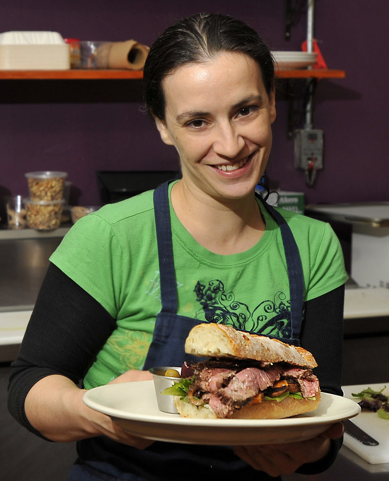 Owner Melissa Coriaty shows off her jerked flank steak sandwich.