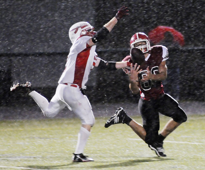 Justin Carlson, left, of Sanford tips a pass away from Scarborough’s Mike Cyr, but pass interference on the play set up the Red Storm’s first TD in a 14-0 win Thursday.