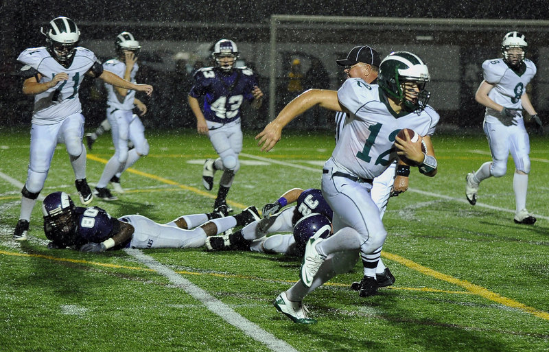 Bonny Eagle quarterback Matt Rollins runs away from the Deering defense during the first half of Thursday’s game at Memorial Field. Rollins rushed for 195 yards and two touchdowns, leading the Scots to a 34-12 victory.