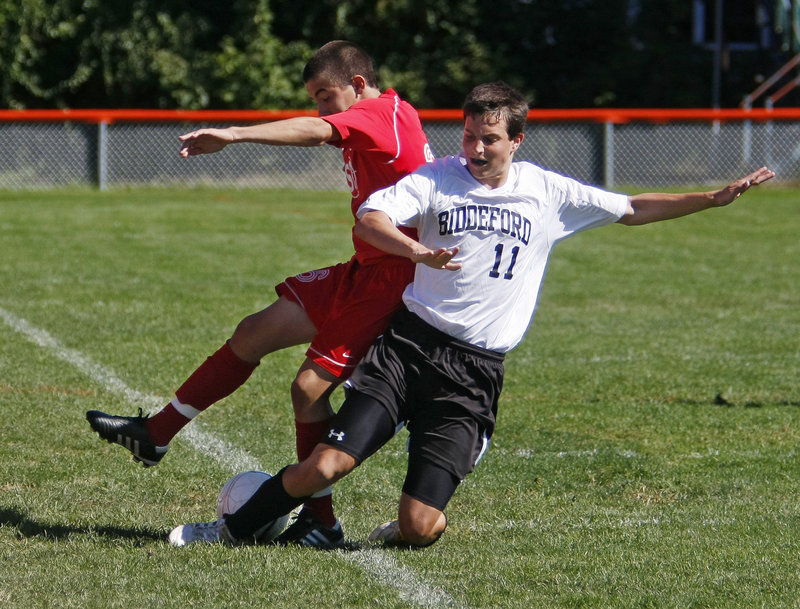 Michael Lachance of Biddeford attempts to knock the ball away from Nate Fox of South Portland during their Southern Maine Activities Association soccer game Saturday at Biddeford. South Portland earned a 5-2 victory.