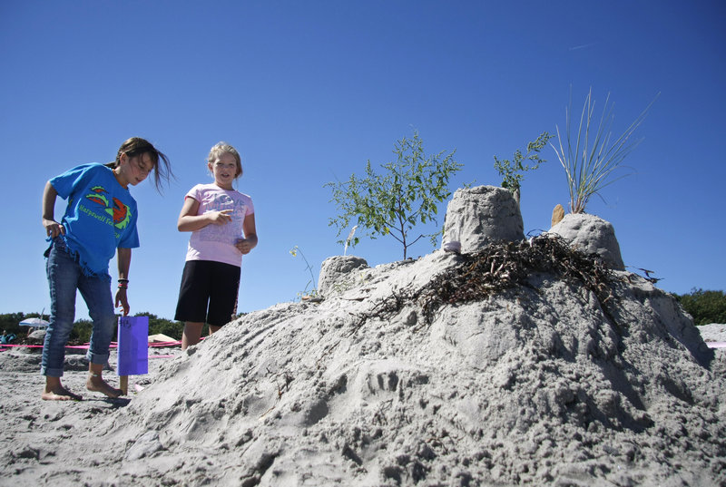 Ava Clifford, left, and Neeley Hunt, above, both 9 and from Portland, talk about their “Zen Garden” sculpture, made with help from Stephanie Hunt and Greg Getchell at Crescent Beach in Cape Elizabeth on Saturday. The girls won an honorable mention.