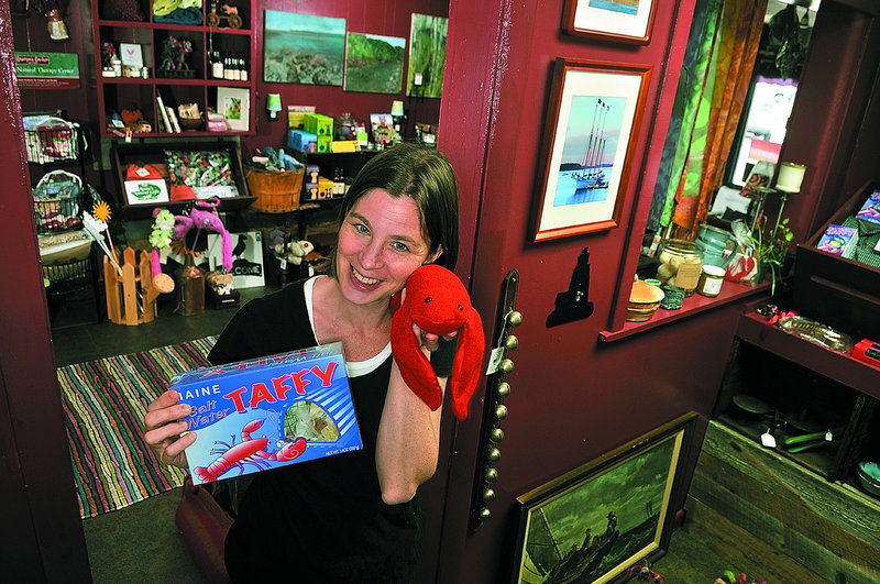 Collaborative organizer Karen Barton holds some of the items for sale at Potato Maine Gifts on Main Street in Winthrop.