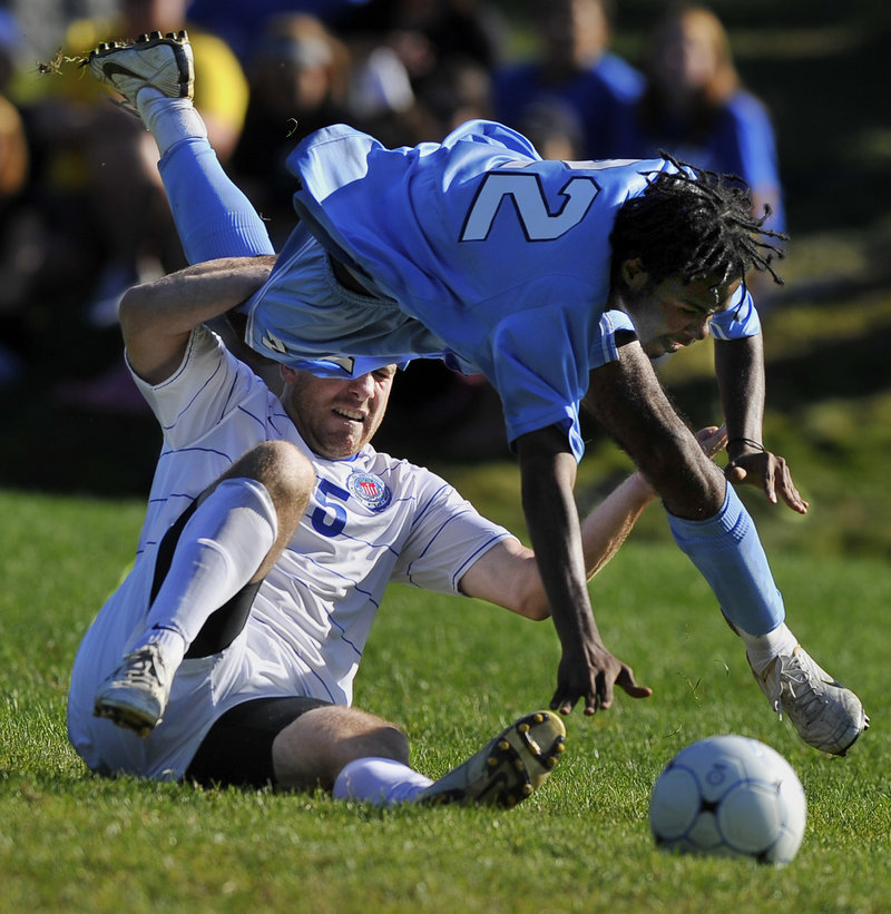 Brandon Noltkamper, bottom, of St. Joseph’s trips up Lasell’s Javon Scott as they battle for a loose ball Saturday during a men’s soccer game at Standish. Lasell won, 3-0.