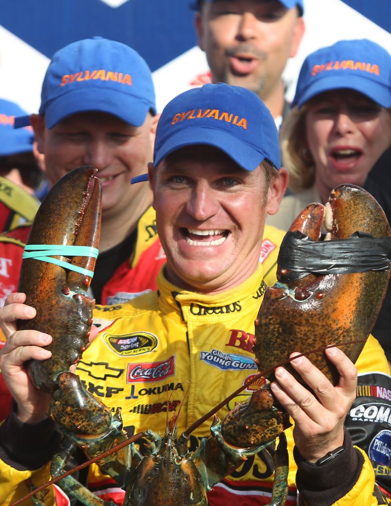 Clint Bowyer hoists a lobster in victory lane in Loudon, N.H., on Sunday after edging Tony Stewart, who lost on a late gamble on fuel.
