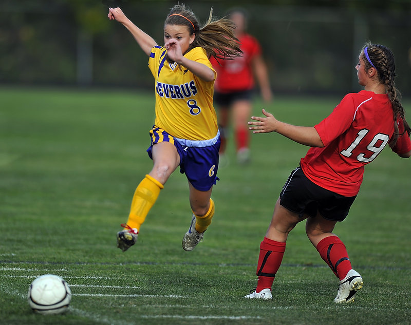 Abby Maker, left, of Cheverus boots the ball past Scarborough’s Jessica Broadhurst during Scarborough’s 2-0 girls’ soccer victory Thursday.