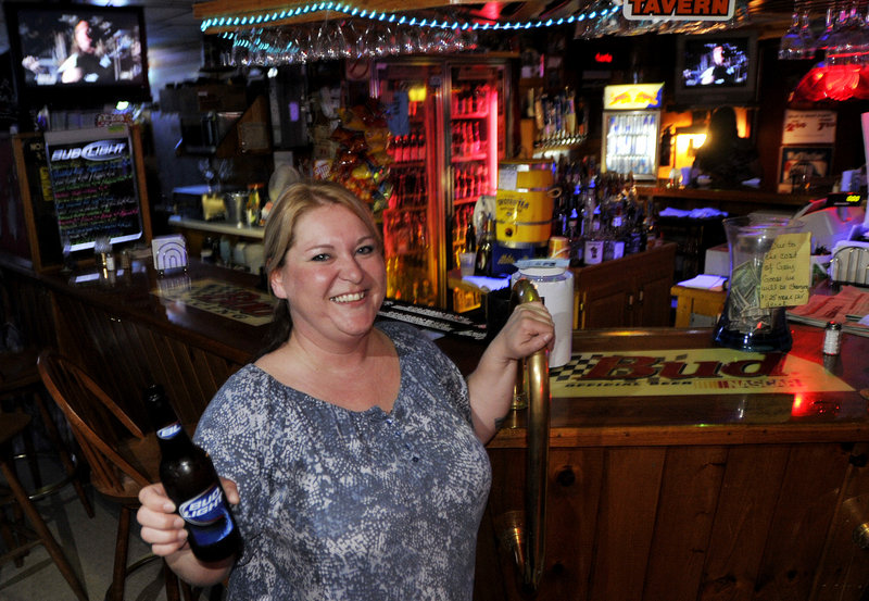 Bartender Krissy Leavitt rounds the corner with a beer for a customer at Buxton Tavern.