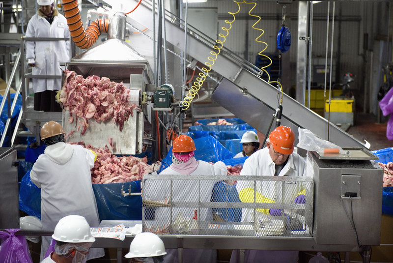 James Achziger, right, samples beef trimmings at the Cargill beef plant in Fort Morgan, Colo. The trimmings are tested for E. coli O157:H7 and turned into ground beef only after testing negative.