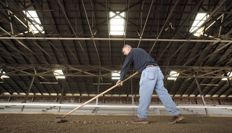 Jim Hawkes of Albion rakes stones out of the pulling ring at the Cumberland Fairgrounds on Friday. The fair opens Sunday and runs through Oct. 2. The first event in the ring is the 3700 and under oxen 6-foot pull, starting at 9 a.m. Sunday.
