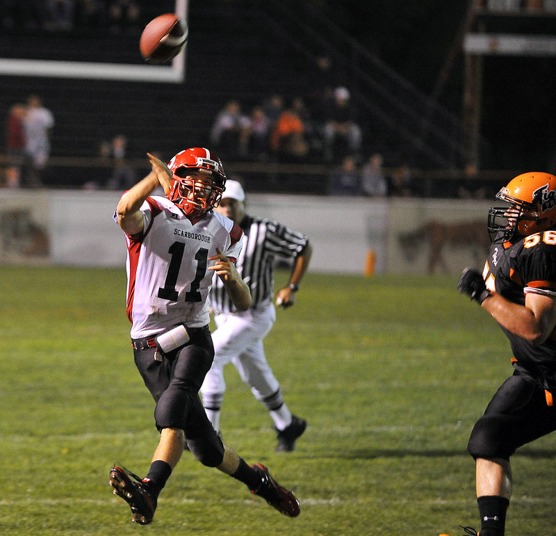 Jack Adams, who passed for 318 yards and three touchdowns Friday night for Scarborough, sends the ball downfield while being pursued by Cody Chaloult of Biddeford. Scarborough came away with a 21-9 victory.