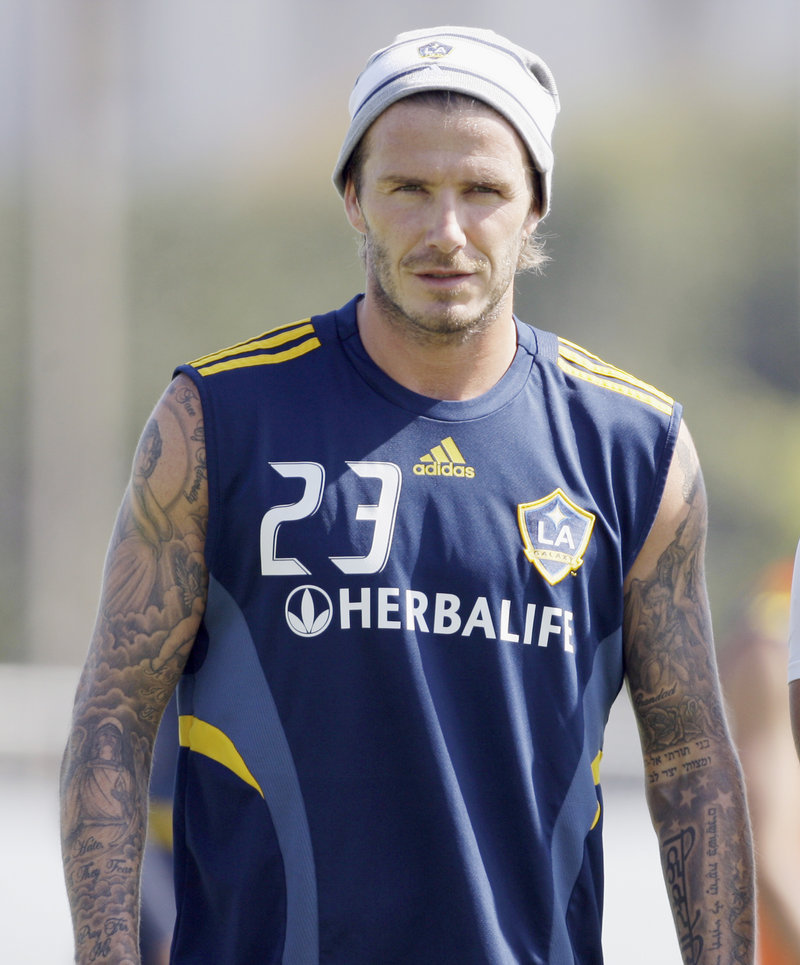Los Angeles Galaxy’s David Beckham watches a soccer training session in Carson, Calif., last week. Beckham’s management company says it is taking legal action against a U.S. magazine that published claims the former England captain slept with prostitutes.