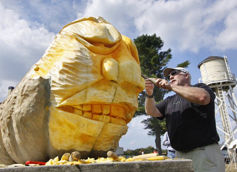 Moe Auger of Alfred makes a sculpture from a giant pumpkin during the Wells Reserve festivities.