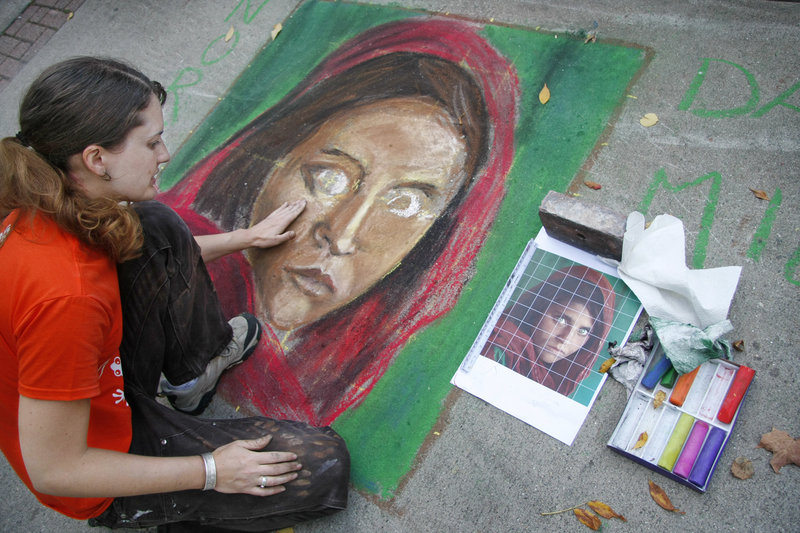 Kim Roseberry of Biddeford uses chalk to re-create the image of an Afghan girl during the Chalk on the Walk event in Biddeford on Saturday. The Afghan girl was photographed by National Geographic photographer Steve McCurry in 1984.