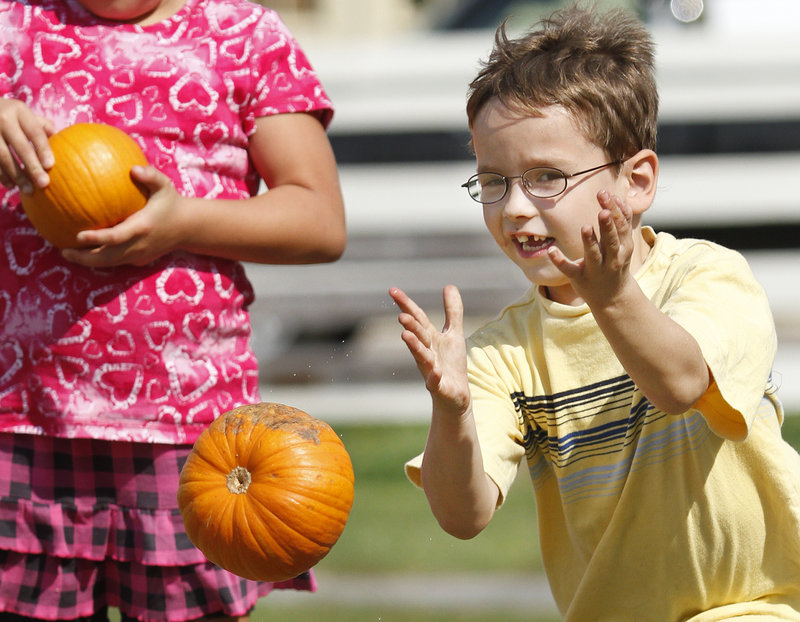 Oliver Robidoux, 6, of Waterboro bowls a pumpkin in one of the games during the Punkinfiddle festival in Wells.