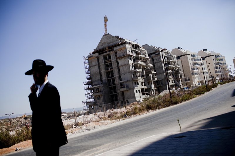 An Ultra-Orthodox Jewish settler walks near a construction site in the West Bank Jewish settlement of Modiin Ilit. Israel imposed the 10-month moratorium in a gesture to get the Palestinians to agree to peace talks.