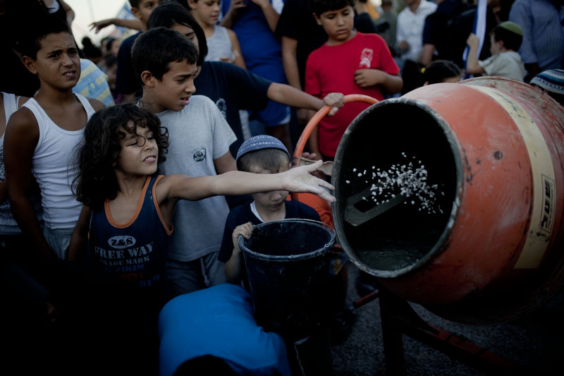 Jewish children throw material into a cement mixer during a symbolic ceremony to renew construction in the West Bank, in the Jewish settlement of Adam, near Ramallah, this month.