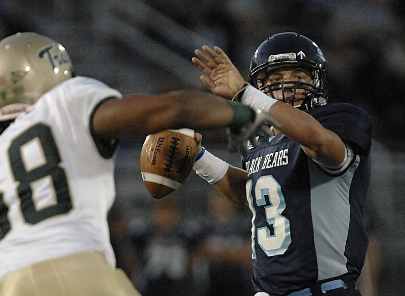 Maine quarterback Warren Smith looks to throw under pressure from William & Mary defensive lineman Bryan Stinnie in the first half Saturday night. Smith helped give the Black Bears a 14-3 lead before the Tribe rallied for a 24-21 win.