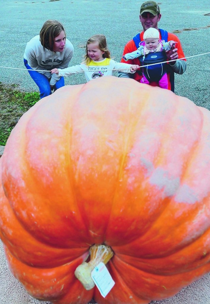 Amanda and Marcel Larochelle of Durham show the large pumpkins to their children Piper and Lilliana at the fair Sunday.