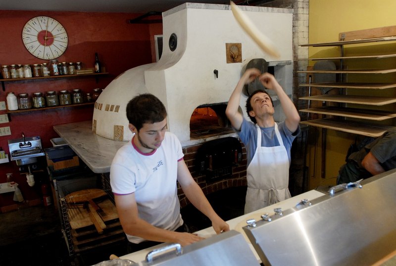 Mihai Dobre and Gabor Gergely make pizzas in the kitchen of Paolina's Way.