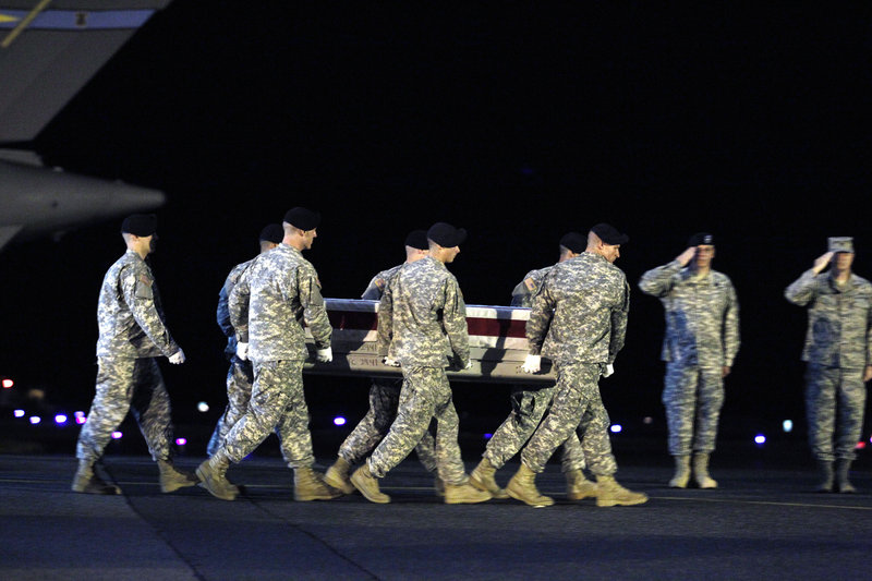 An Army team carries the transfer case containing the remains of Army Pfc. Clinton E. Springer II upon arrival at Dover Air Force Base in Delaware on Sunday.