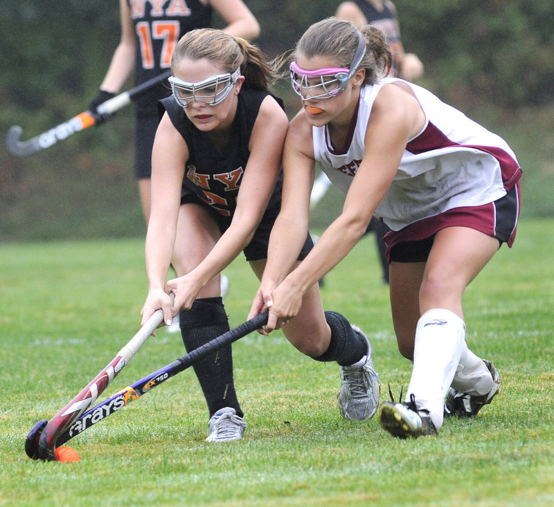 Jen Brown, left, of North Yarmouth Academy battles with Jenny Breau of Freeport during NYA s 5-0 field hockey victory Monday.