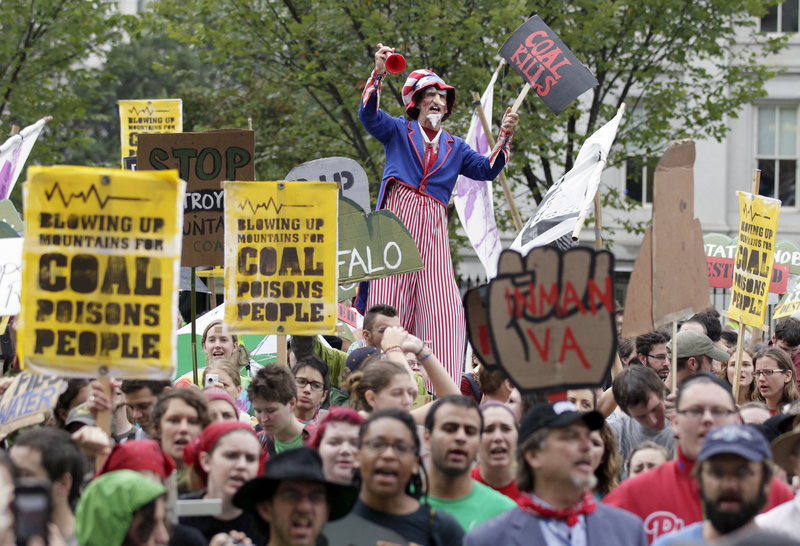 Protesters, including a man on stilts called “Uncle Scam,” gather in Washington on Monday during a demonstration calling for the end of mountaintop removal mining. About 100 people were arrested after refusing to leave the sidewalk in front of the White House.