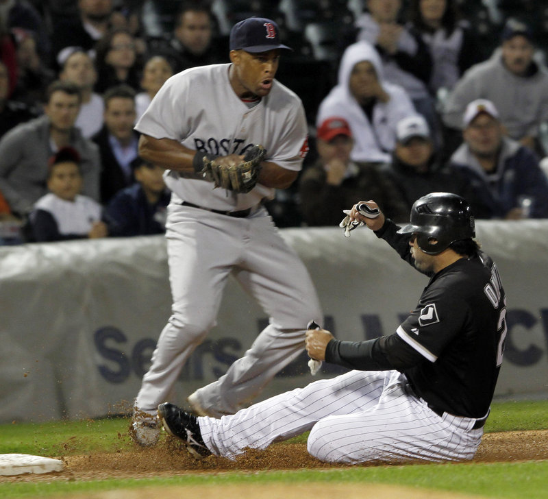 Carlos Quentin of the White Sox slides under the throw to Boston third baseman Adrian Beltre, advancing on a double by Alexei Ramirez, but the Red Sox picked up a 6-1 win at Chicago.