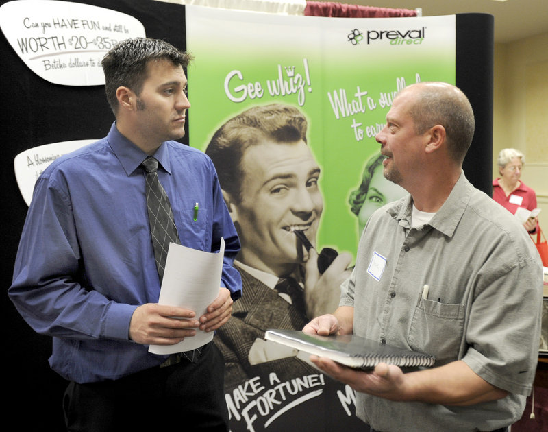 Jason Izzard, left, with Preval Direct, talks to Steve Kibler of Augusta on Tuesday during a career fair at the Italian Heritage Center in Portland. About 800 job hunters showed up for the event.