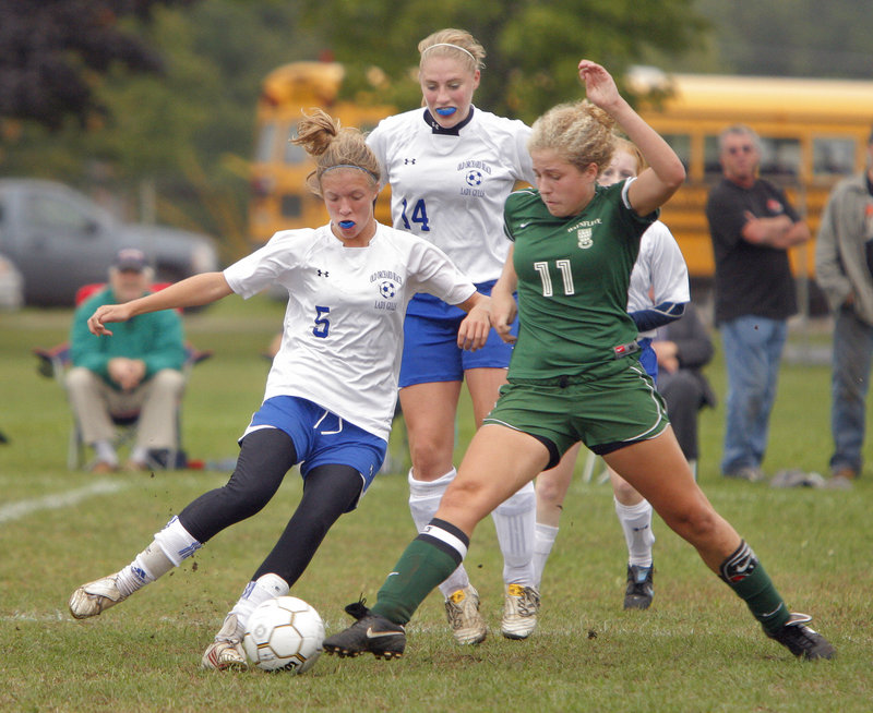 Anna Foss of Old Orchard Beach, left, and Elizabeth Berrang of Waynflete try to gain control of the ball Tuesday during Waynflete's 1-0 victory. Behind them is Katie Hatch of Old Orchard Beach.