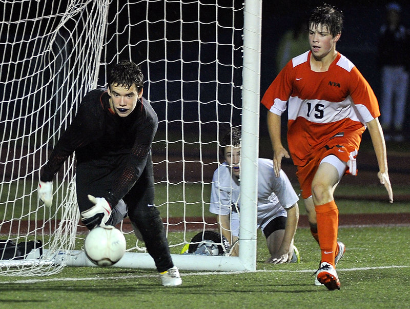 Sam Torres of Yarmouth looks through the net Tuesday night to see if his pass across the front of the goal finds a teammate. North Yarmouth Academy goalie Ryan Salerno chases the ball as Forrest Milburn of the Panthers moves in. Yarmouth came away with a 1-0 victory.