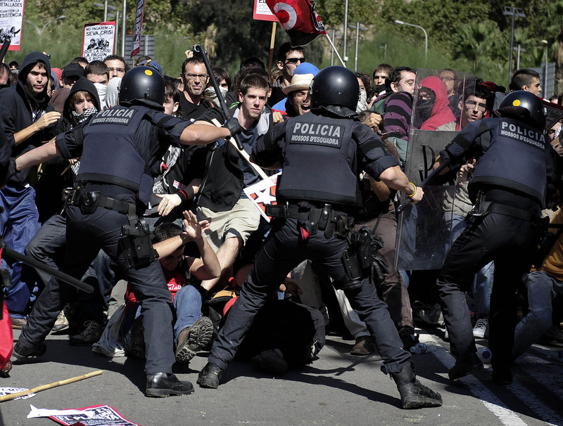 Riot police push back a wave of demonstrators during protests Wednesday in Barcelona, Spain. Spanish workers staged a general strike Wednesday to protest austerity measures imposed by a government struggling to slash its budget deficit and overcome recession.