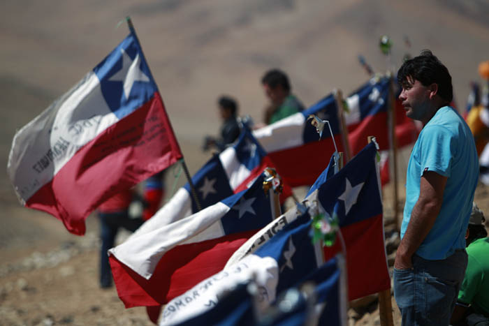Luis Acuna, brother of trapped miner Claudio Acuna, one of the 33 trapped miners, stands next to Chilean flags today at the San Jose Mine, near Copiapo, Chile.
