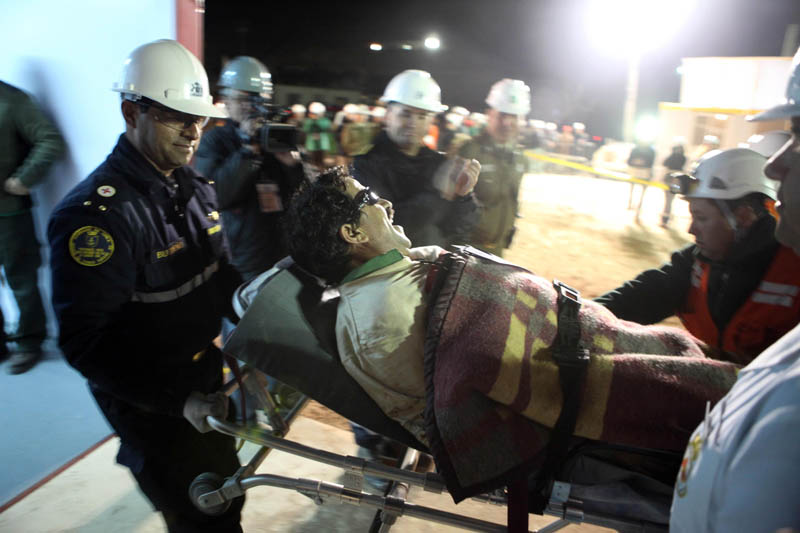 In this photo released by the Chilean government, miner Juan Illanes is carried away on a stretcher after being rescued from the mine today.