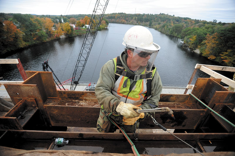 WORK IN PROGRESS: Bud Greene, an iron worker with Reed and Reed, prepares to secure a temporary brace atop the one standing arch of the new Norridgewock bridge last week.