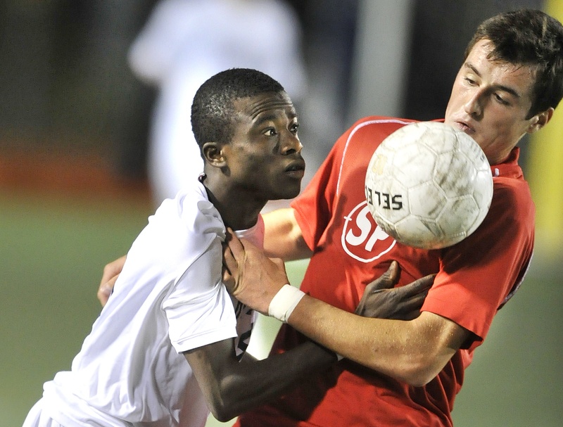 Portland's Tony Yekah, left, and South Portland's Nemanja Kaurin fight for control of the ball during Monday's game.