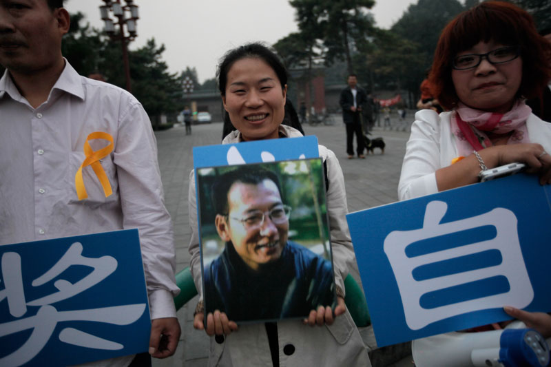 Supporters of Liu Xiaobo holding his picture gather outside a park in Beijing Friday, Oct. 8, 2010. Imprisoned Chinese dissident Liu won the 2010 Nobel Peace Prize on Friday for using non-violence to demand fundamental human rights in his homeland. The award ignited a furious response from China, which accused the Norwegian Nobel Committee of violating its own principles by honoring "a criminal." (AP Photo/Vincent Yu)
