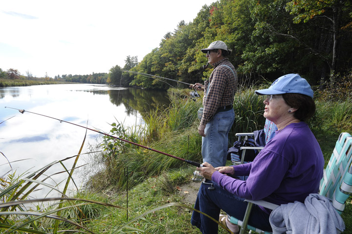 Retirees Barbara and Sal Moscato from Brunswick enjoy one of the last few fishing days today, sitting on the banks of the Muddy River in Topsham to catch a few.