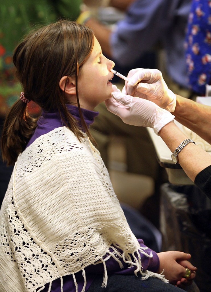Kate Friberg, 8, of Cape Elizabeth gets a second dose of H1N1 flu mist at a clinic at the Cape Elizabeth Fire Station on Tuesday. Vaccine doses are readily available in Maine, even to healthy adults.