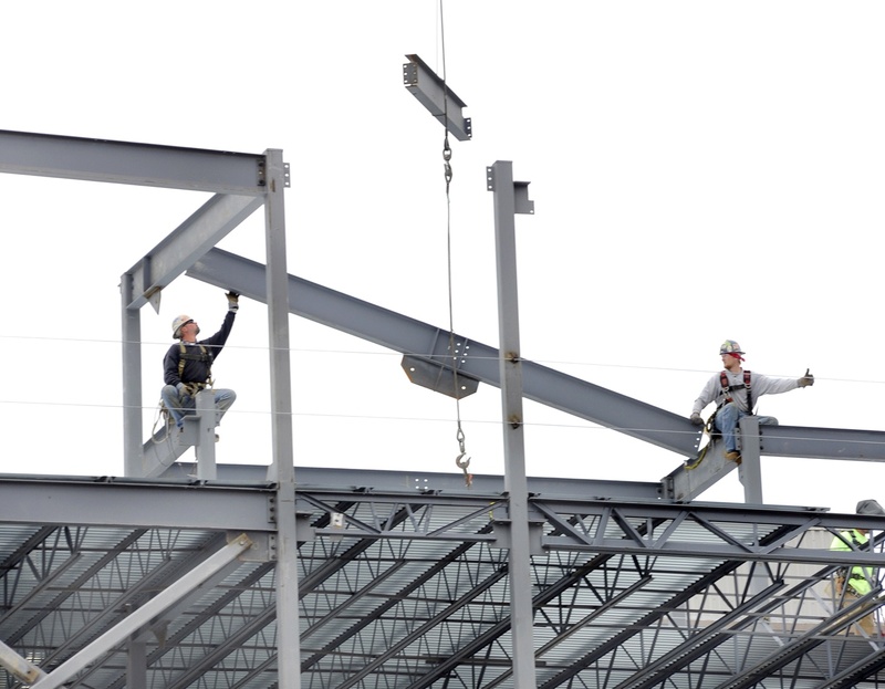 Iron workers connect steel beams on a hotel, restaurant and condo project, part of a recent surge in  commercial projects in Portland. 