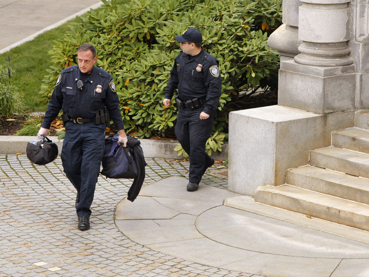 Federal courthouse security personnel carry a duffel bag and backpack away from the entrance to the federal courthouse in Portland today. Police closed down Federal Street for five hours as they tried to determine what was in the package.