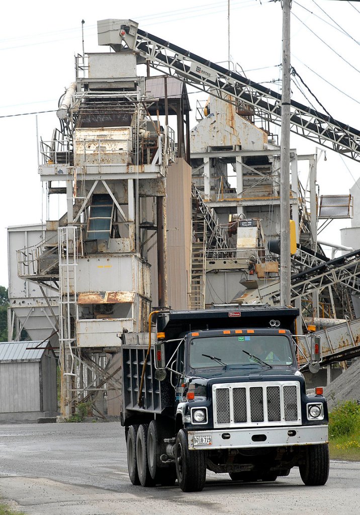 A truck leaves Pike Industries facility in Westbrook. The firm s application to blast at a local quarry remains disputed by neighbors.
